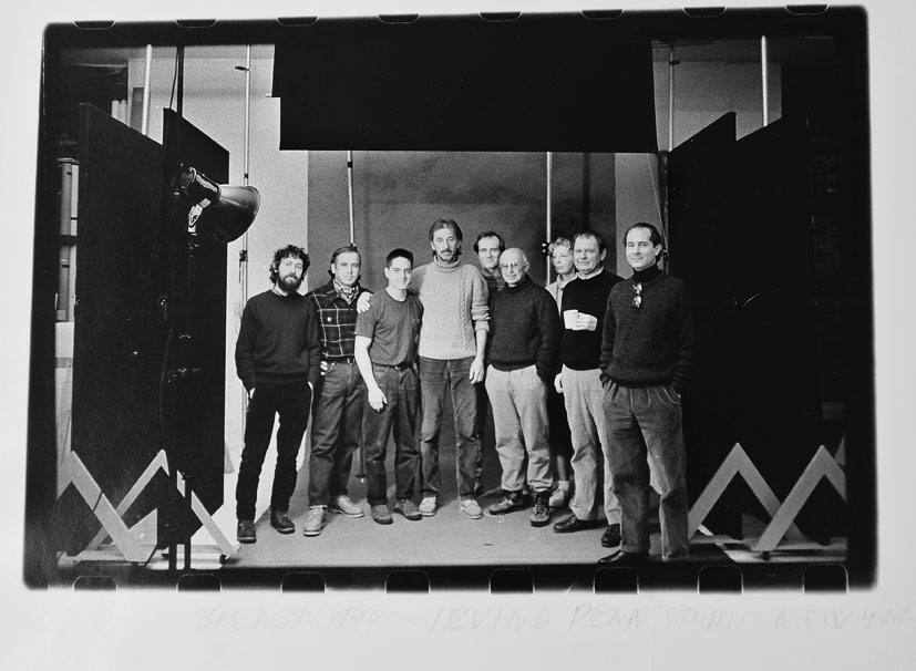 Eight crew members on a photography set in a windowless studio with a spotlight and dark flats, 1990.