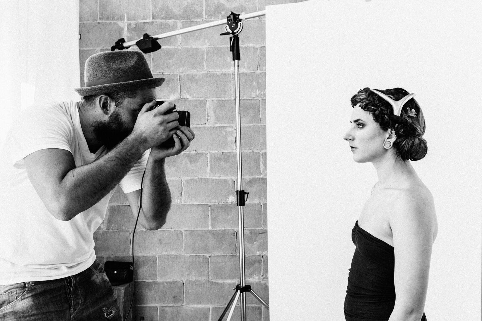 Photographer taking a portrait of a model in a studio