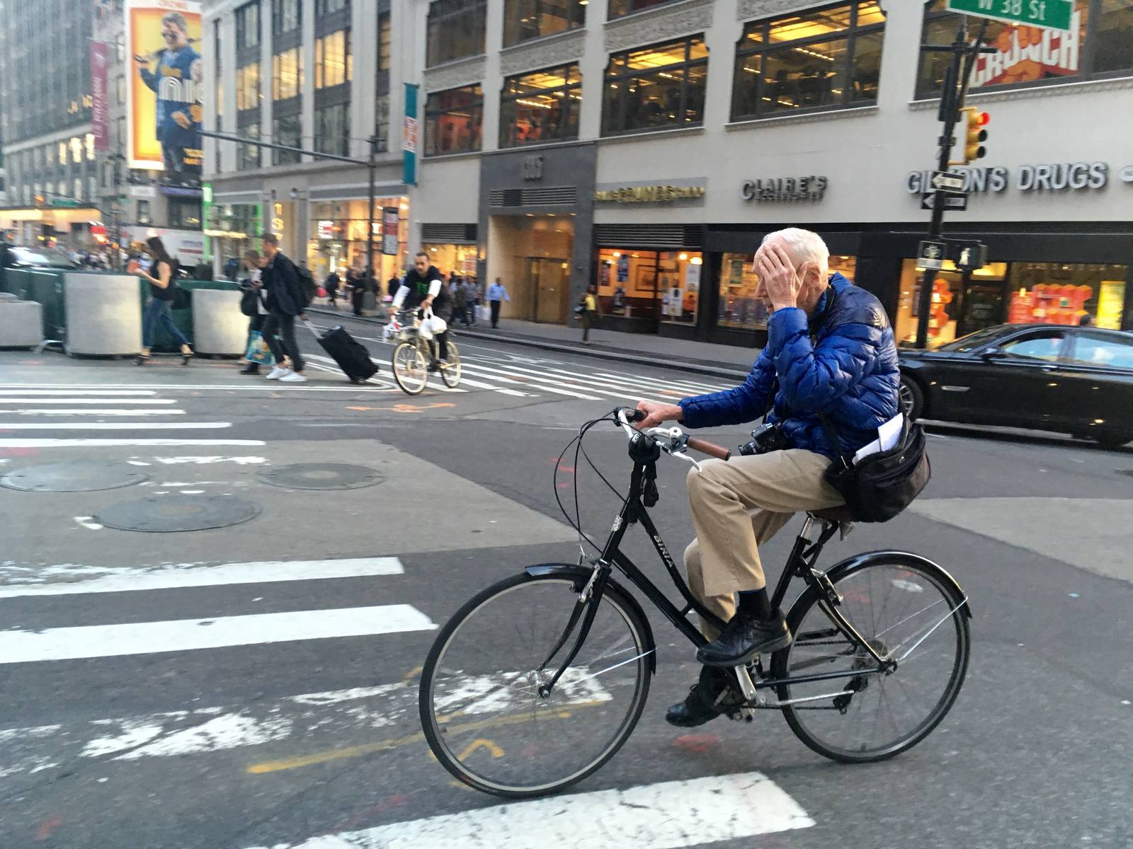 Bill Cunningham riding a bicycle in Midtown Manhattan